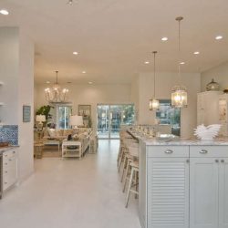 Spacious, modern kitchen with light cabinetry, island seating, and open view to a bright living and dining area.